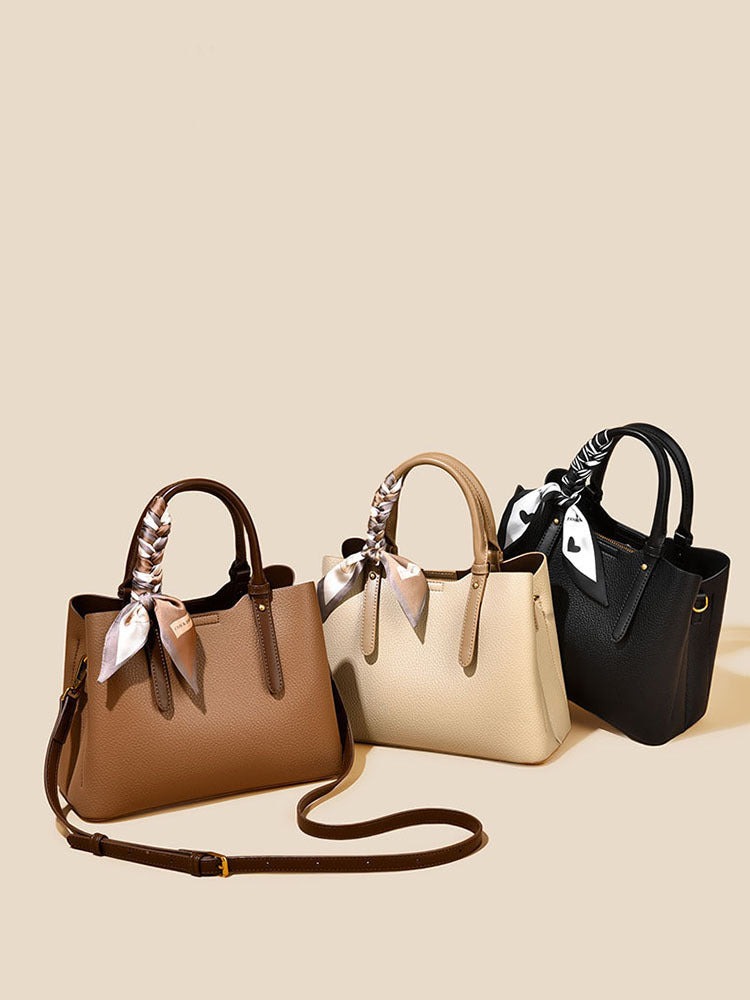 Three elegant pebbled tote bags with scarves and detachable straps, in brown, beige, and black.